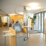 Ein Selbstbedienungsterminal im Kundenservicebereich mit einer Person, die es benutzt.