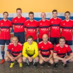 Eine Gruppe von Fußballspielern in roten Trikots mit dem Logo von Aptar auf einem Sportfeld.
