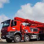 Roter Betonpumpen-Lkw mit der Aufschrift 'Bachl' und einem langen Ausleger.
