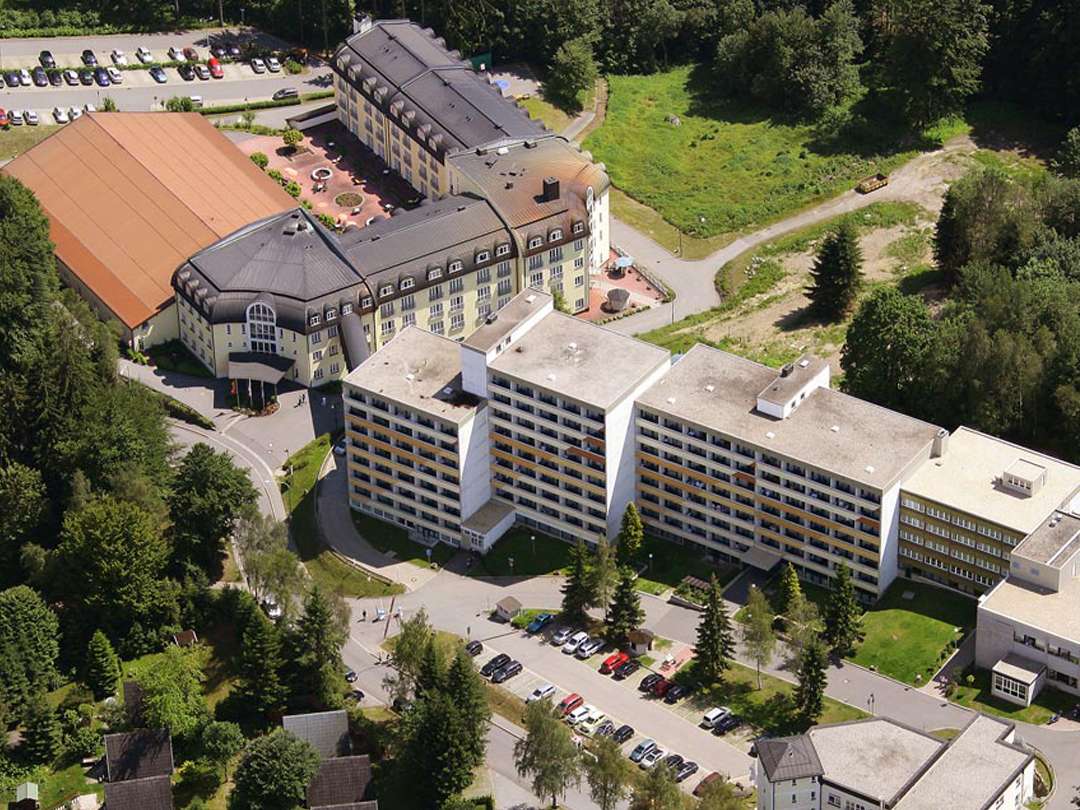 Luftaufnahme eines Gesundheitszentrums mit mehreren Gebäuden und Parkplätzen.
