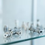 Eine Ansammlung von verschiedenen Metallverbindungsstücken auf einer Glasoberfläche.