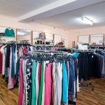 Kleiderständer mit verschiedenen Kleidungsstücken in einem Bekleidungsgeschäft.