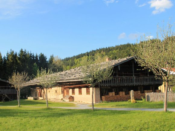 Traditionelles Bauernhaus im Freilichtmuseum mit Holzstruktur und grünem Rasen.