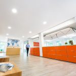 Bürointerieur mit orangefarbenen Schließfächern und einer Weltkarte an der Wand.