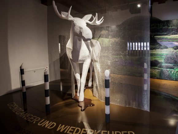 Weiße Skulptur eines Elches, die in einem Museum ausgestellt ist.