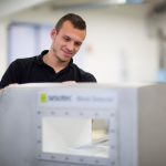 Ein Mitarbeiter bedient ein Sortiergerät in einer industriellen Umgebung.
