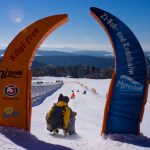 Eingang zur Rodelbahn im Familien-Winterland Mitterdorf mit orangefarbenen Bögen.