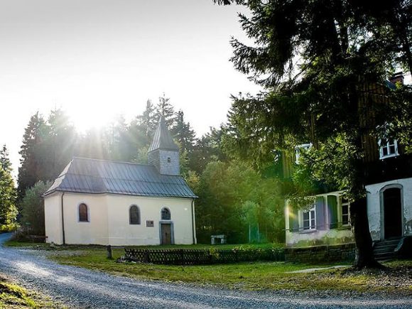 Eine kleine Kapelle mit einem spitzen Dach und einem Glockenturm in Leopoldsreut.