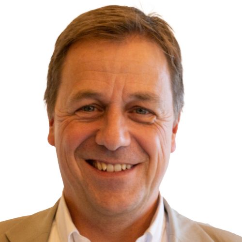 Porträt eines Mannes mit lächelndem Gesicht und braunen Haaren vor weißem Hintergrund.
