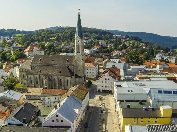 Luftaufnahme einer Stadt mit einer Kirche und umliegenden Gebäuden in Waldkirchen.
