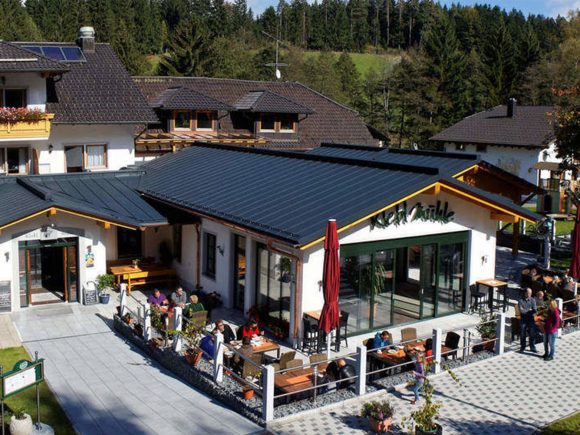 Das Klebmühle Restaurant mit einer großen Glasfront und einer Terrasse mit Tischen und Stühlen.