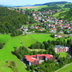 Luftaufnahme einer ländlichen Gegend mit Wohnhäusern und grünen Feldern in Deutschland.