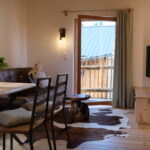 Ein gemütliches Wohnzimmer mit einer Ledercouch, einem Holztisch und einem Fernseher an der Wand.