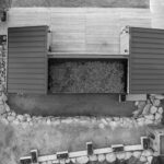 Dachansicht eines modernen Gartenhauses mit zwei geöffneten Dächern und einem leeren Innenraum.