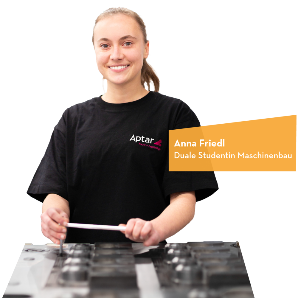 Junge Frau mit einem schwarzen T-Shirt, die an einer Maschine arbeitet und lächelt.
