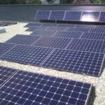 Reihe von Solarpanelen auf einem Dach, angeordnet in mehreren Reihen.