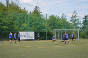 Gruppe von Fußballspielern in blauen Trikots auf einem Sportplatz während des Trainings.