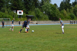 Zwei Fußballspieler im Wettkampf um den Ball auf einem Rasenplatz während eines Spiels.