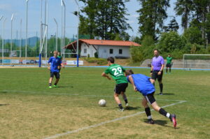 Zwei Fußballspieler im Wettkampf um den Ball auf einem Rasenplatz.