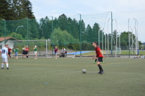 Ein Spieler in rotem Trikot bereitet sich darauf vor, den Ball während eines Fußballspiels zu spielen.