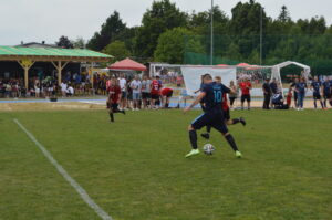 Ein Spieler mit der Nummer 10 führt einen Freistoß während eines Fußballspiels auf einem Rasenplatz aus.