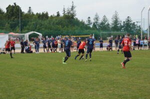 Fußballspieler in blauen und roten Trikots auf einem Spielfeld während eines Spiels.