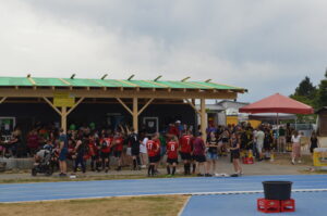 Gruppierung von Sportlern und Zuschauern bei einer Veranstaltung im Freien.