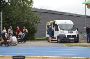Ein Foodtruck mit dem Namen Tiziano, umgeben von Menschen auf einem Sportgelände.