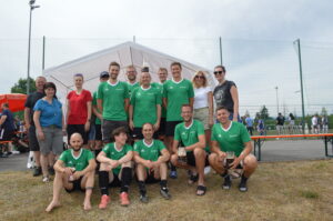 Sportteam in grünen Trikots posiert für ein Gruppenfoto im Freien.