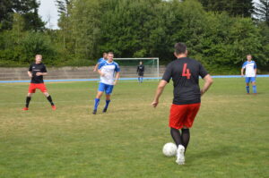 Spieler in roten und blauen Trikots auf einem Fußballfeld während eines Spiels.