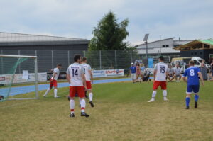 Fußballspieler in roten und weißen Trikots auf dem Spielfeld während eines Spiels.