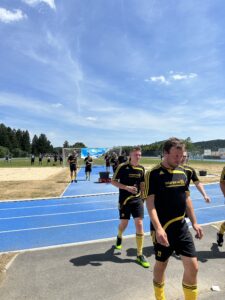 Eine Fußballmannschaft in schwarzen und gelben Trikots verlässt das Spielfeld nach dem Training.