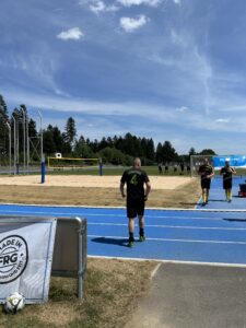 Ein Fußballspieler in schwarzer Kleidung mit der Nummer 41 auf einem Sportplatz mit blauer Laufbahn.