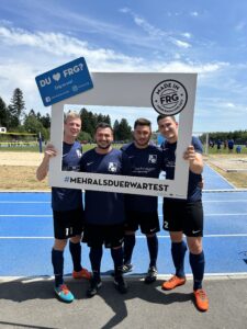 Vier Fußballspieler posieren in einem Rahmen mit dem Text 'DU ♥ FRG?' und '#MEHRALSDUERWARTEST'.