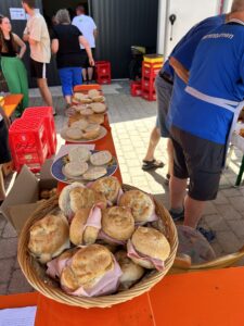 Ein Korb mit Brötchen, gefüllt mit Schinken, auf einem Tisch bei einer Veranstaltung.