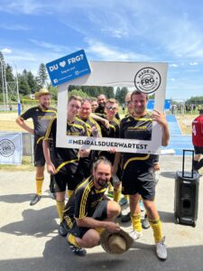 Sechs Fußballspieler posieren in einem Rahmen mit dem Text 'DU ♥ FRG?' und '#MEHRALSDUERWARTEST'.