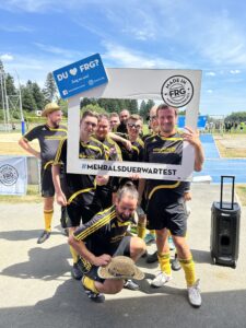 Eine Gruppe von Fußballspielern posiert mit einem großen Rahmen, der den Hashtag #MEHRALSDUERWARTEST zeigt.