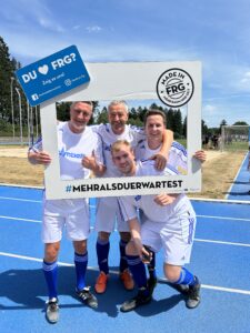 Vier Fußballspieler posieren in einem Rahmen mit dem Hashtag #MEHRALSDUERWARTEST.