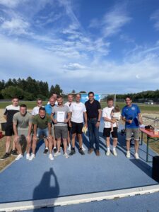 Eine Gruppe von Personen posiert für ein Foto nach einer Sportveranstaltung im Freien.