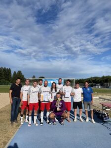 Eine Fußballmannschaft posiert mit einem Pokal und Urkunden nach einem Turnier.