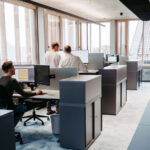 Moderne Büros mit mehreren Arbeitsplätzen und Computern in einem hellen Raum.