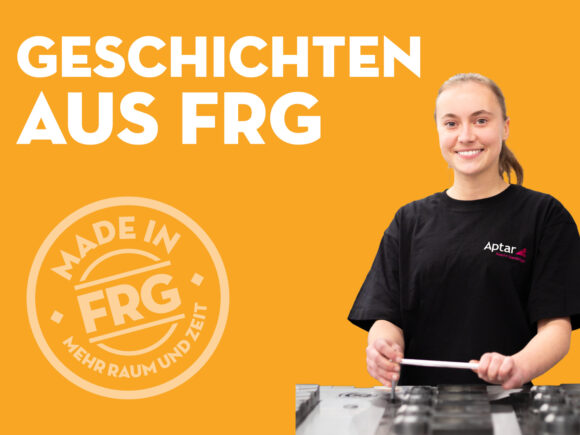 Frau in einem Aptar T-Shirt steht an einer Produktionsmaschine und hält ein Werkzeug in der Hand.