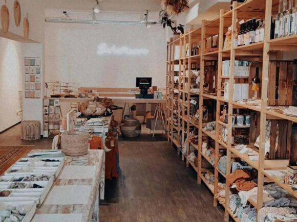 Innenansicht eines Einzelhandelsgeschäfts mit Holzregalen und verschiedenen Produkten.