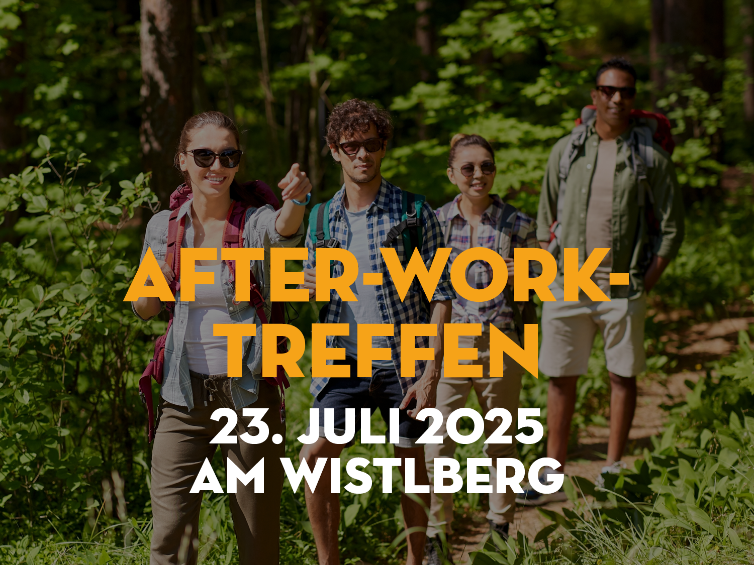 Gruppe von vier Personen im Freien, die in die Kamera lächeln und auf einen Weg zeigen.