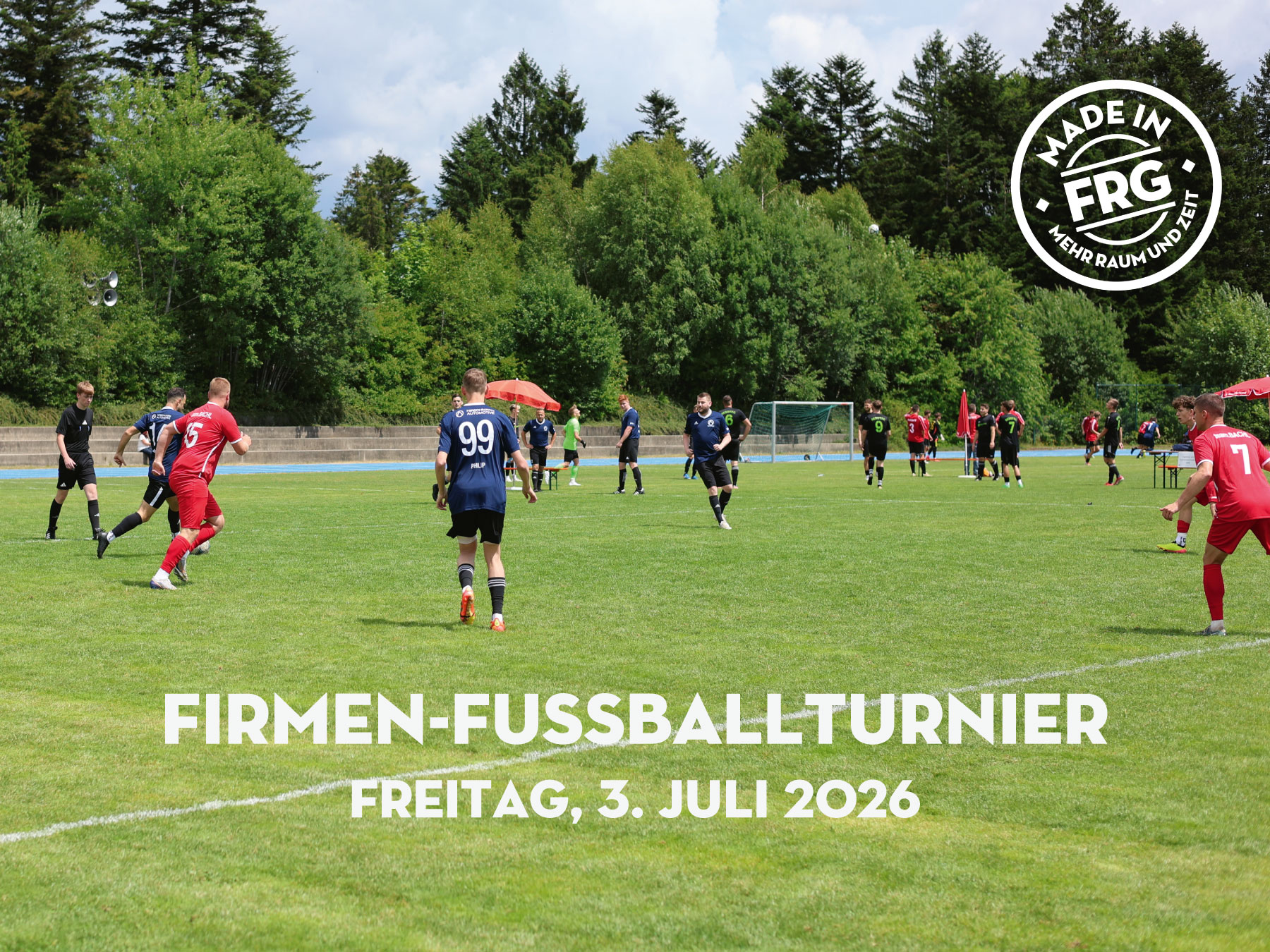 Spieler in roten und blauen Trikots während eines Firmen-Fußballturniers auf einem Rasenplatz.