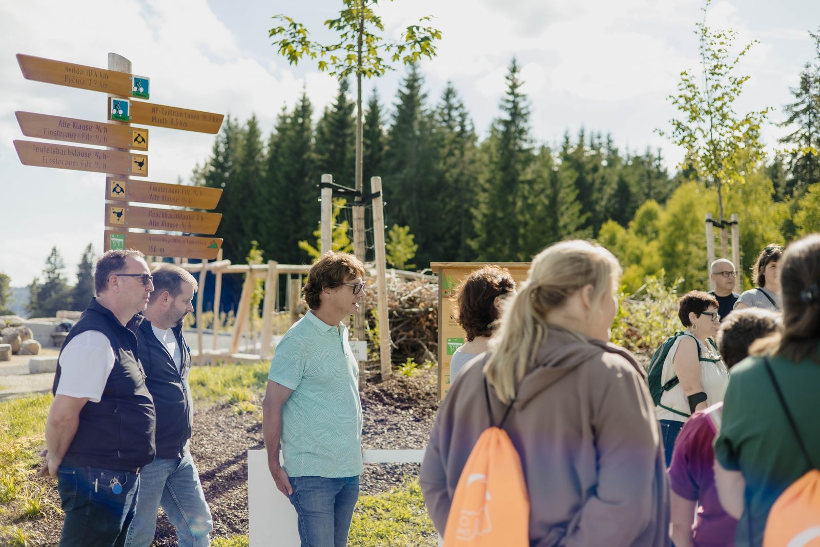 Beim MADE in FRG After-Work-Treffen stehen Teilnehmende am Wistlberg neben hölzernen Wegweisern im Naturerlebnisgebiet.