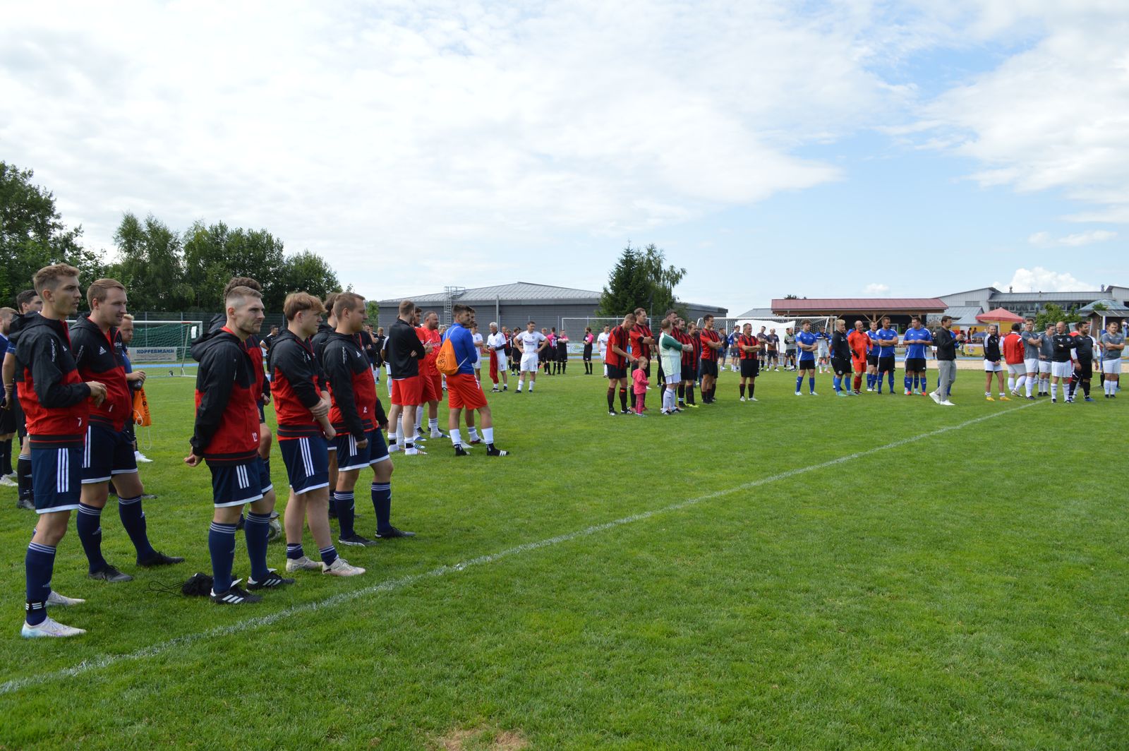Auf dem Sportgelände des TV Freyung stehen Firmenteams in verschiedenen Trikots beim Firmenfußballturnier 2025 auf dem Rasen.
